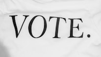 Bold black lettering spells out the word 'VOTE.' on a plain white background. The typography is simple and clear, conveying a direct message.