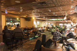 Cozy pub interior with warm lighting and a lively crowd enjoying drinks and live music.