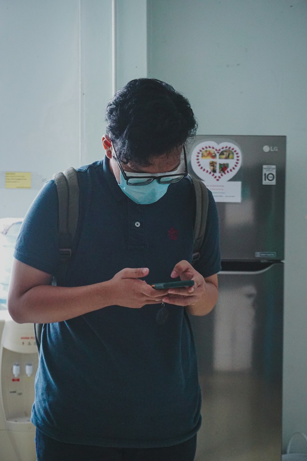 hombre con polo azul usando un teléfono inteligente