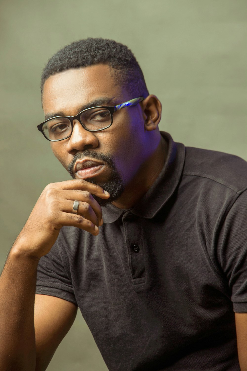 man in black polo shirt wearing black framed eyeglasses