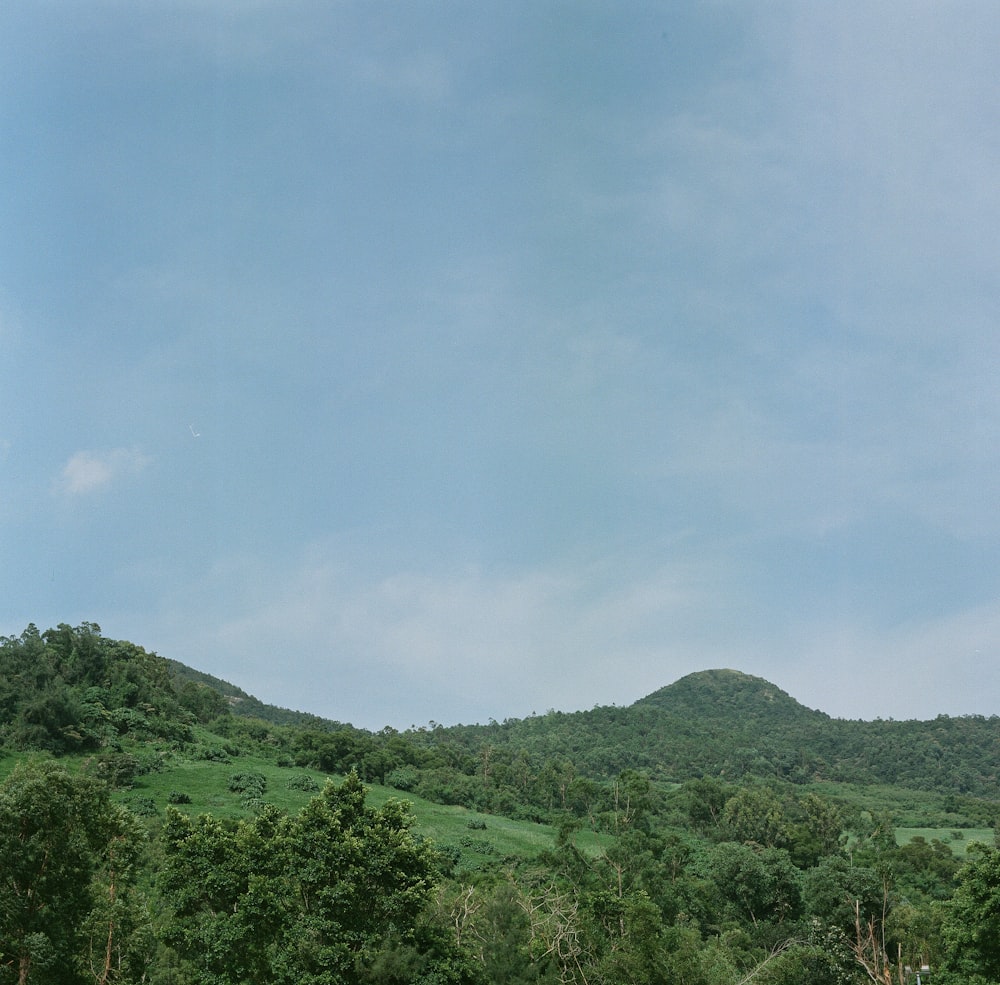 green mountain under white clouds during daytime