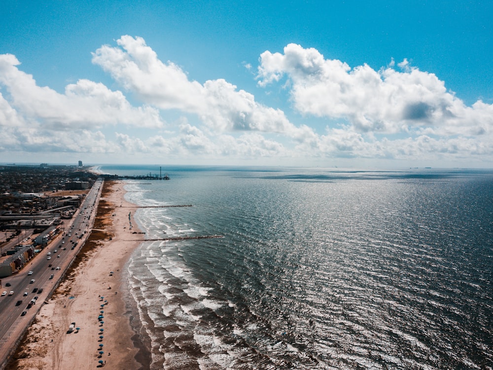 sea waves crashing on shore under blue and white cloudy sky during daytime