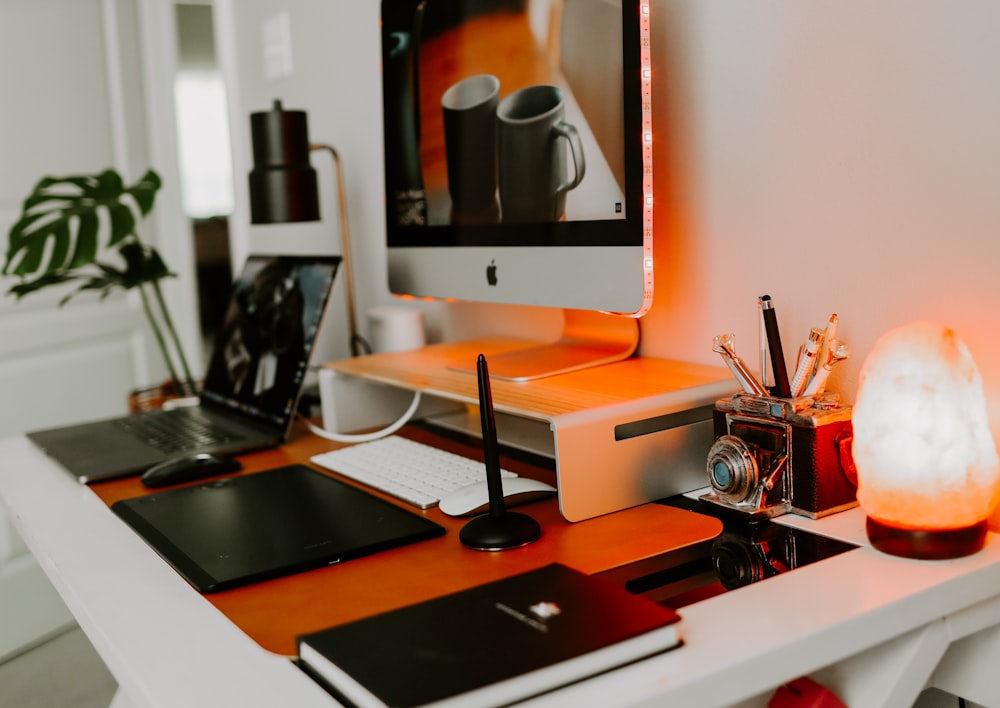 Imac argenté sur bureau en bois noir