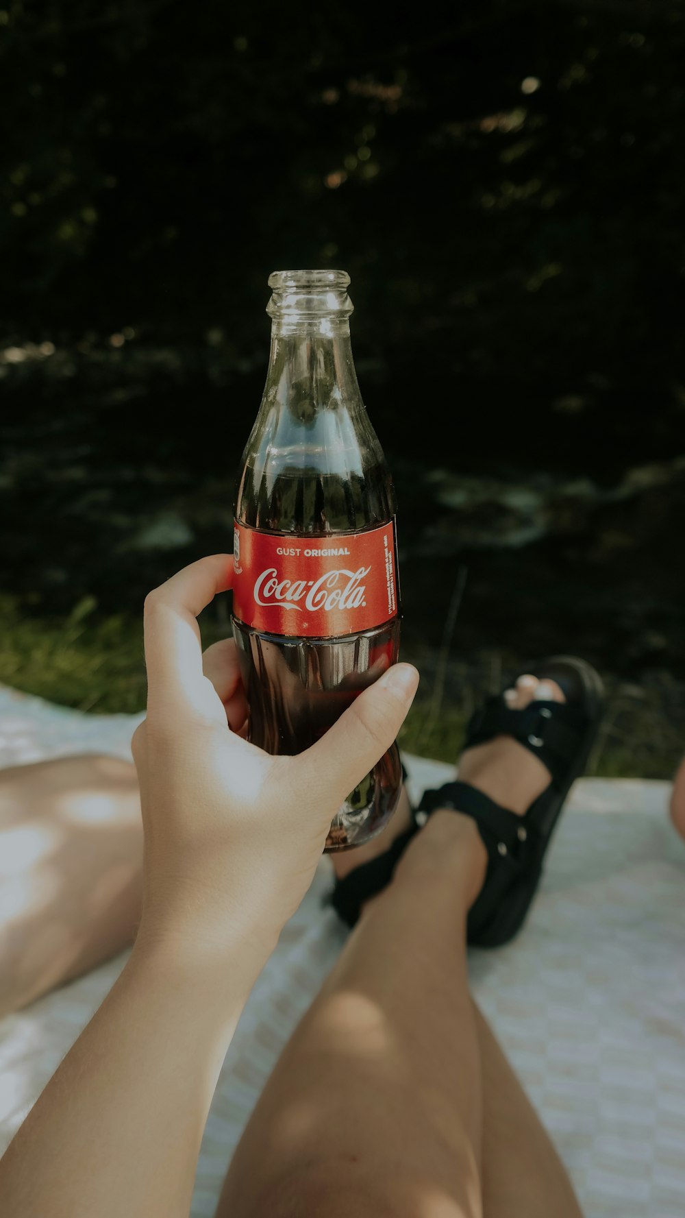 coca cola bottle on persons hand