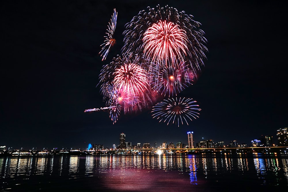 fireworks display over city buildings during night time