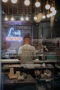 man in white t-shirt standing in front of table