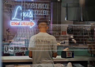 man in white t-shirt standing in front of table