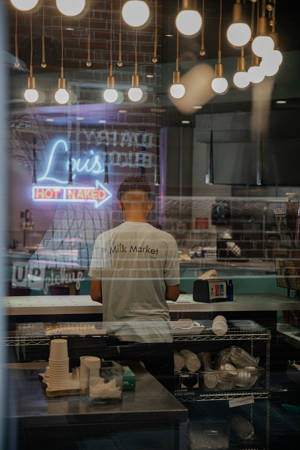 man in white t-shirt standing in front of table