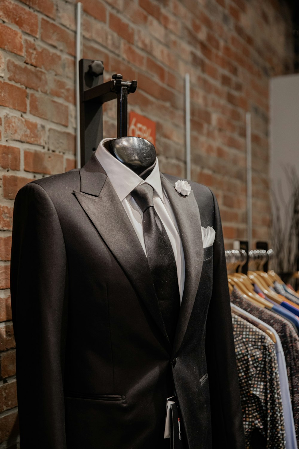 black suit jacket near brown brick wall