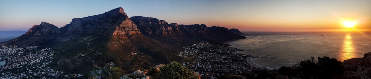 A panoramic view of Ras Al Khaimah’s mountains meeting the coastline at sunset.