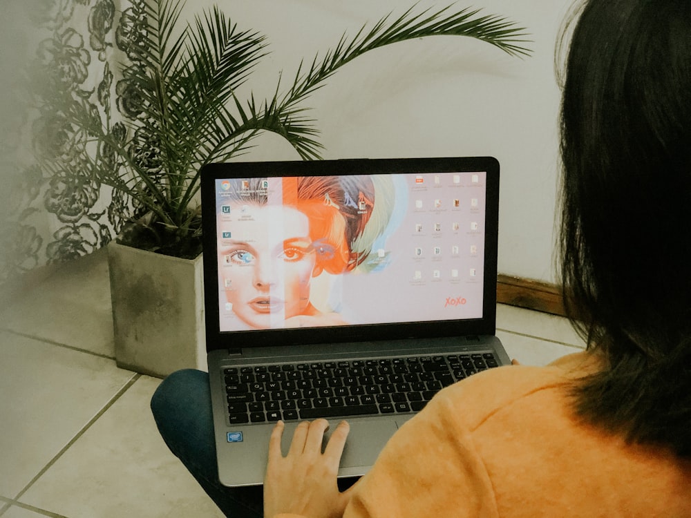 woman in yellow long sleeve shirt using macbook pro