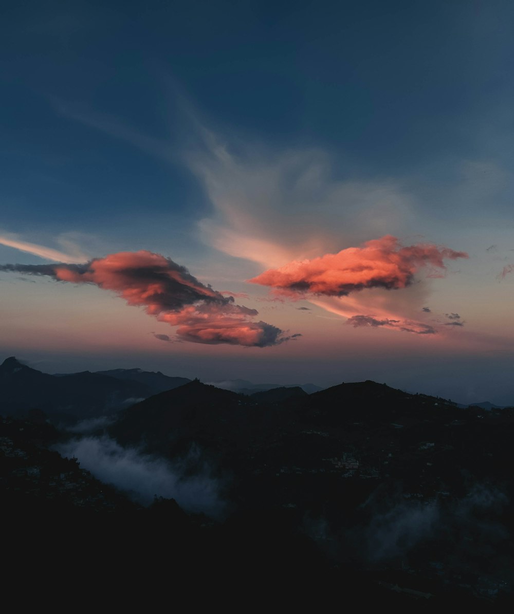 silhouette of mountain under cloudy sky during sunset