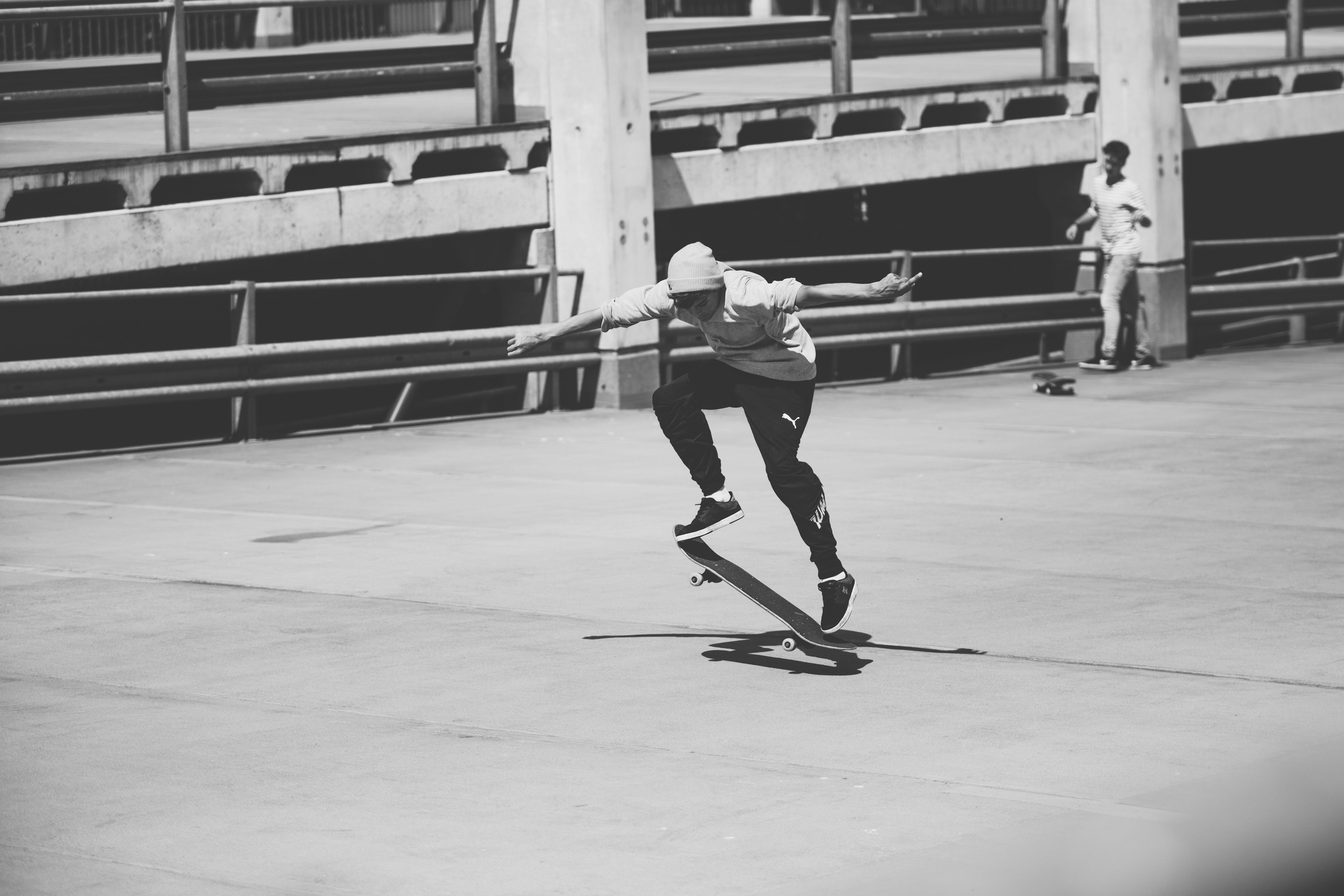 man in white long sleeve shirt and black pants playing skateboard