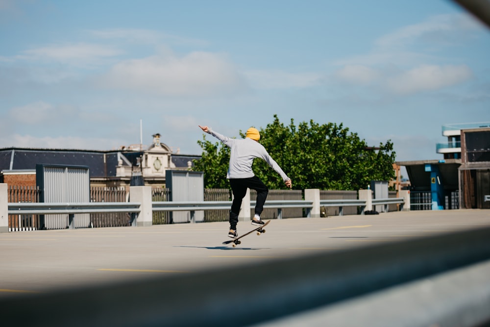 man in white shirt and black pants playing skateboard during daytime