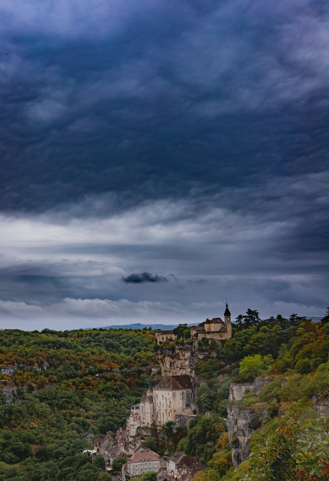 gray concrete building on top of hill under gray clouds