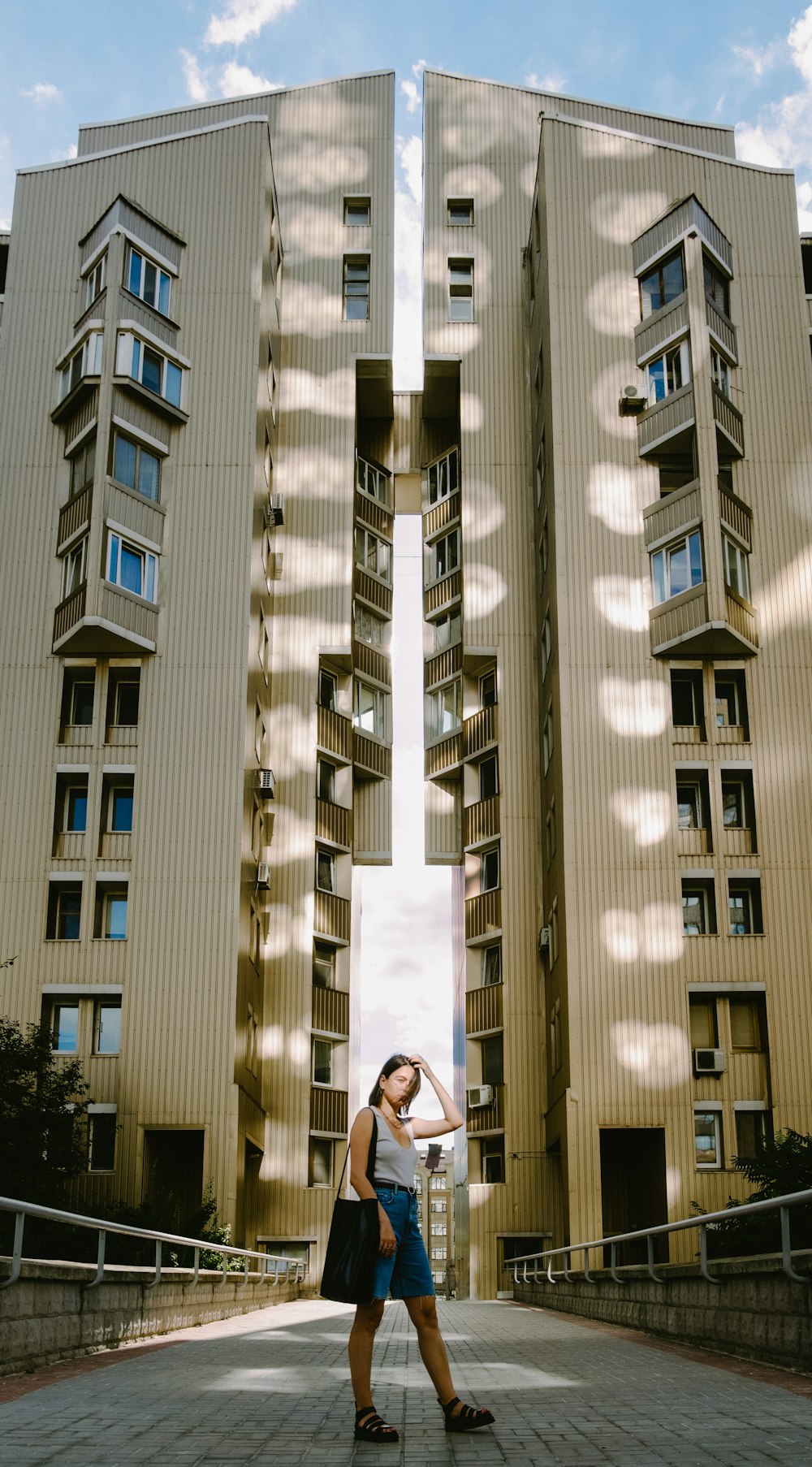 woman in black jacket standing near brown concrete building during daytime