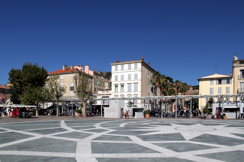 people walking on park near white concrete building during daytime