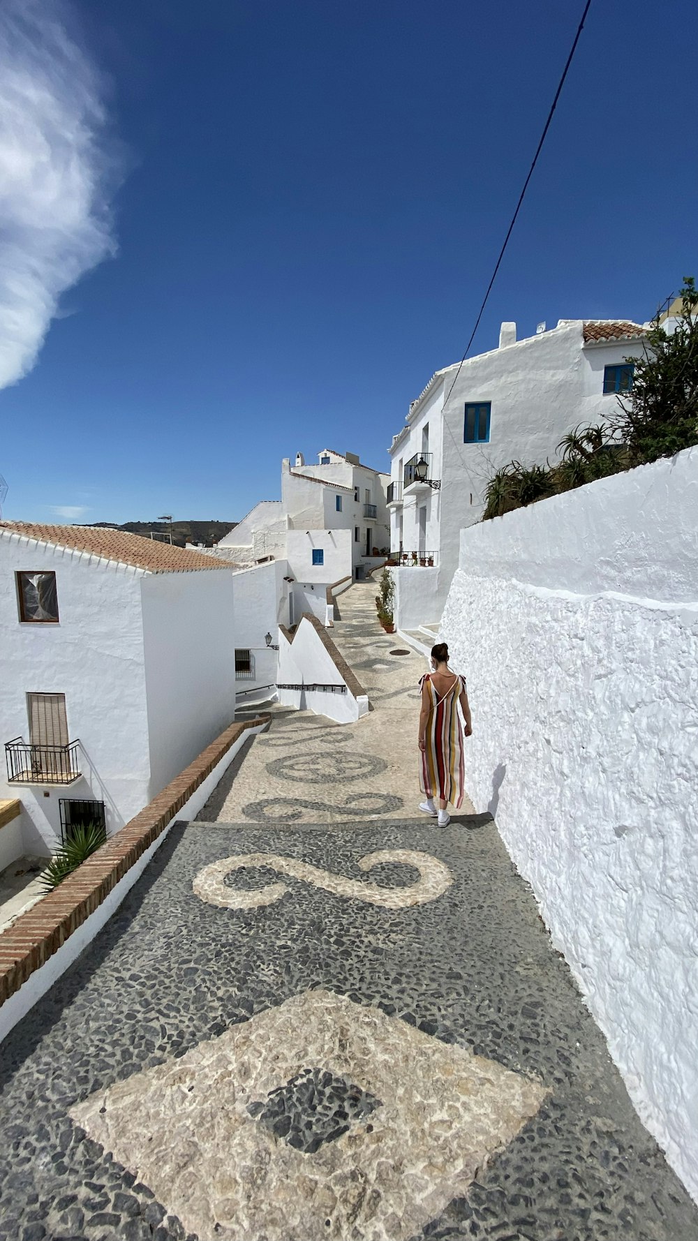 woman in white dress standing on white concrete wall during daytime