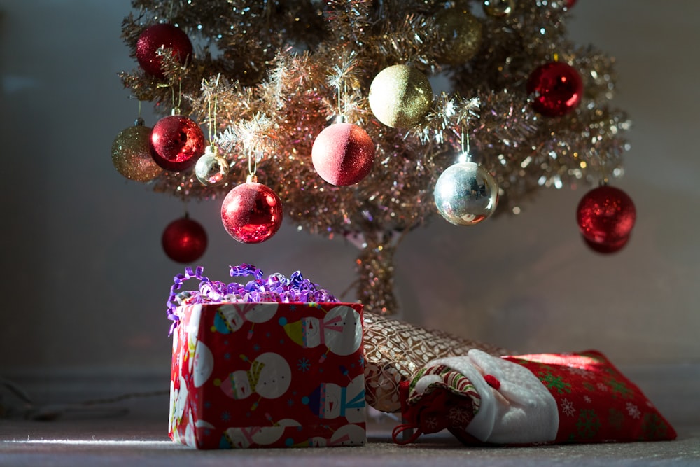 red and white polka dot gift box under white and red baubles