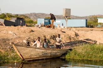 people on brown wooden boat on brown sand during daytime