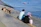 man and woman sitting on concrete dock near body of water during daytime