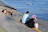 man and woman sitting on concrete dock near body of water during daytime