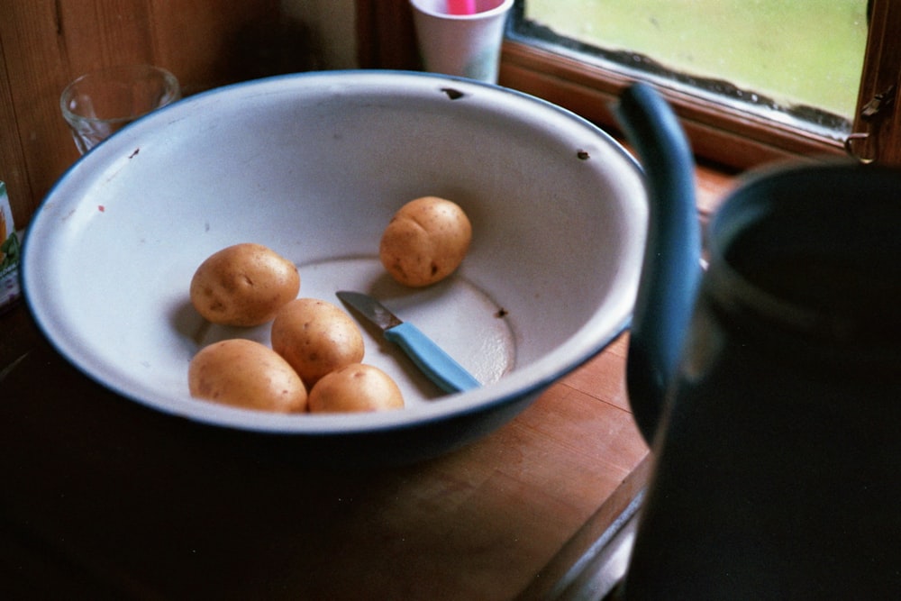 brown round fruit on white ceramic bowl