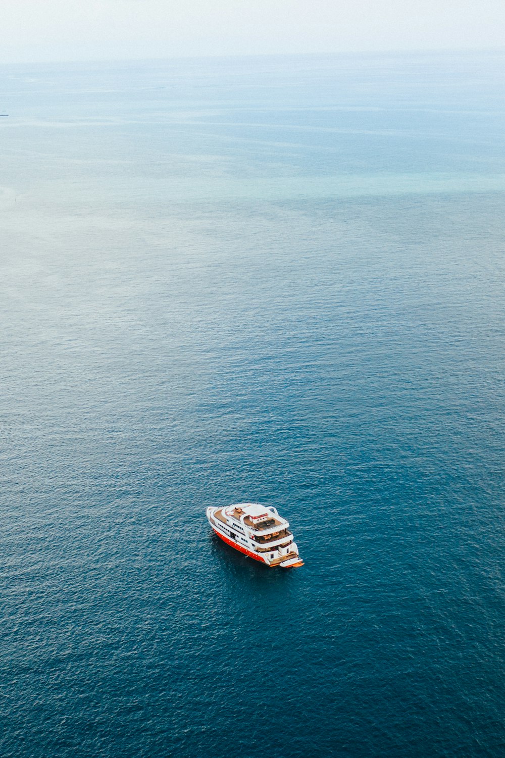 white and red boat on sea during daytime