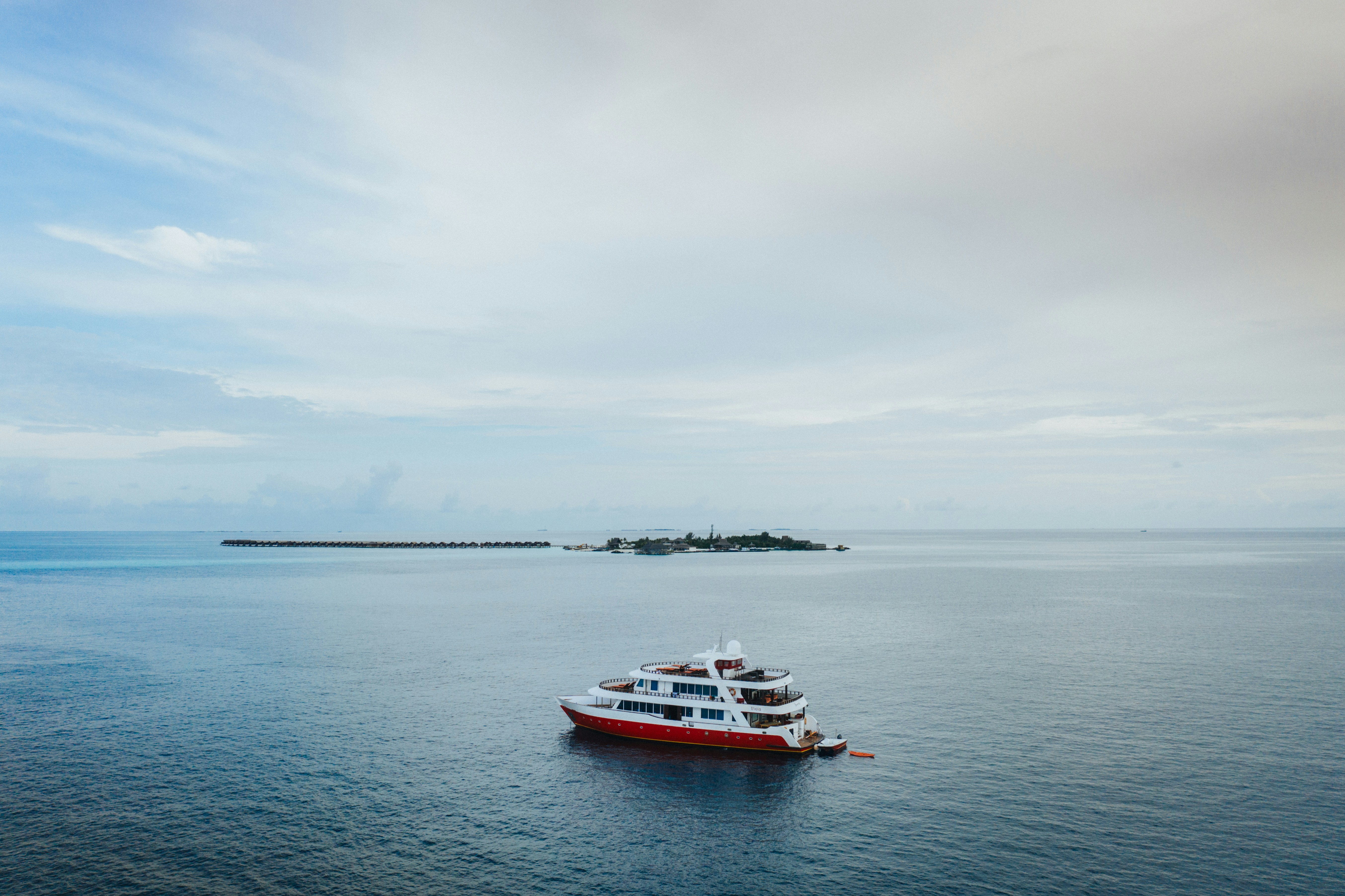 Red and white boat on sea under white sky during daytime photo – Free ...