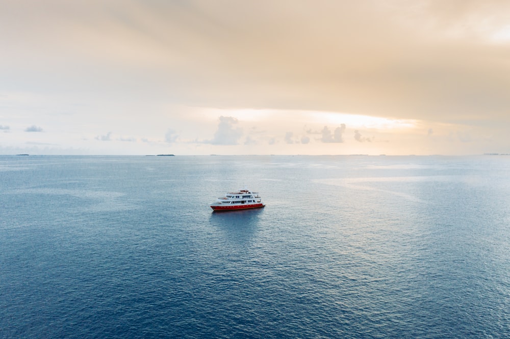 navio vermelho e branco no mar durante o dia