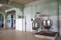 Industrial kitchen area with machines processing food ingredients.