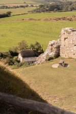 A scenic view of a classic British countryside with rolling green hills and a historic stone cottage.