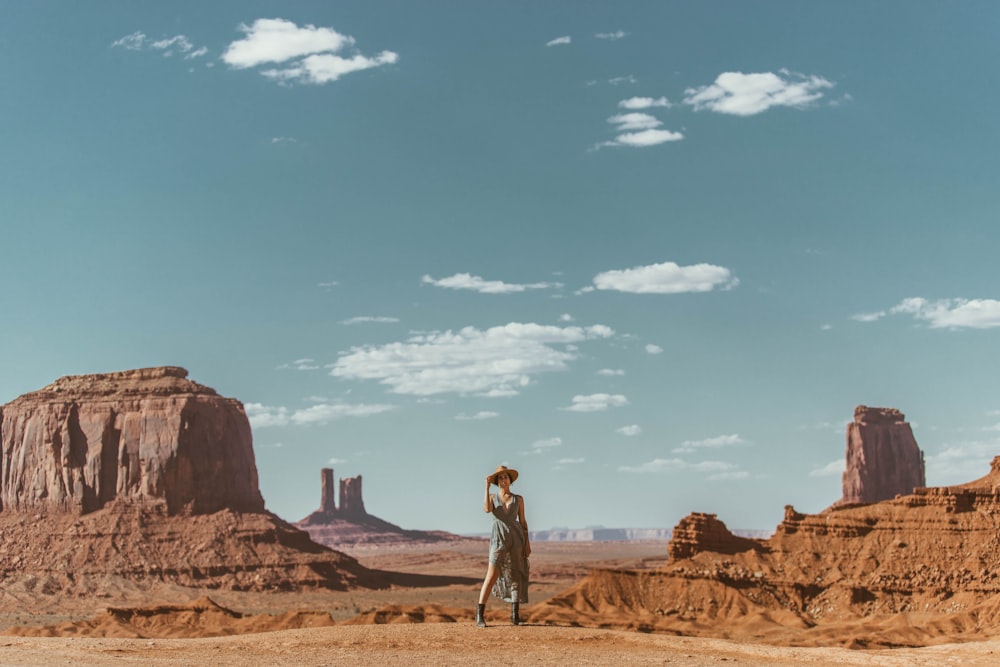 man and woman walking on brown sand under blue sky during daytime