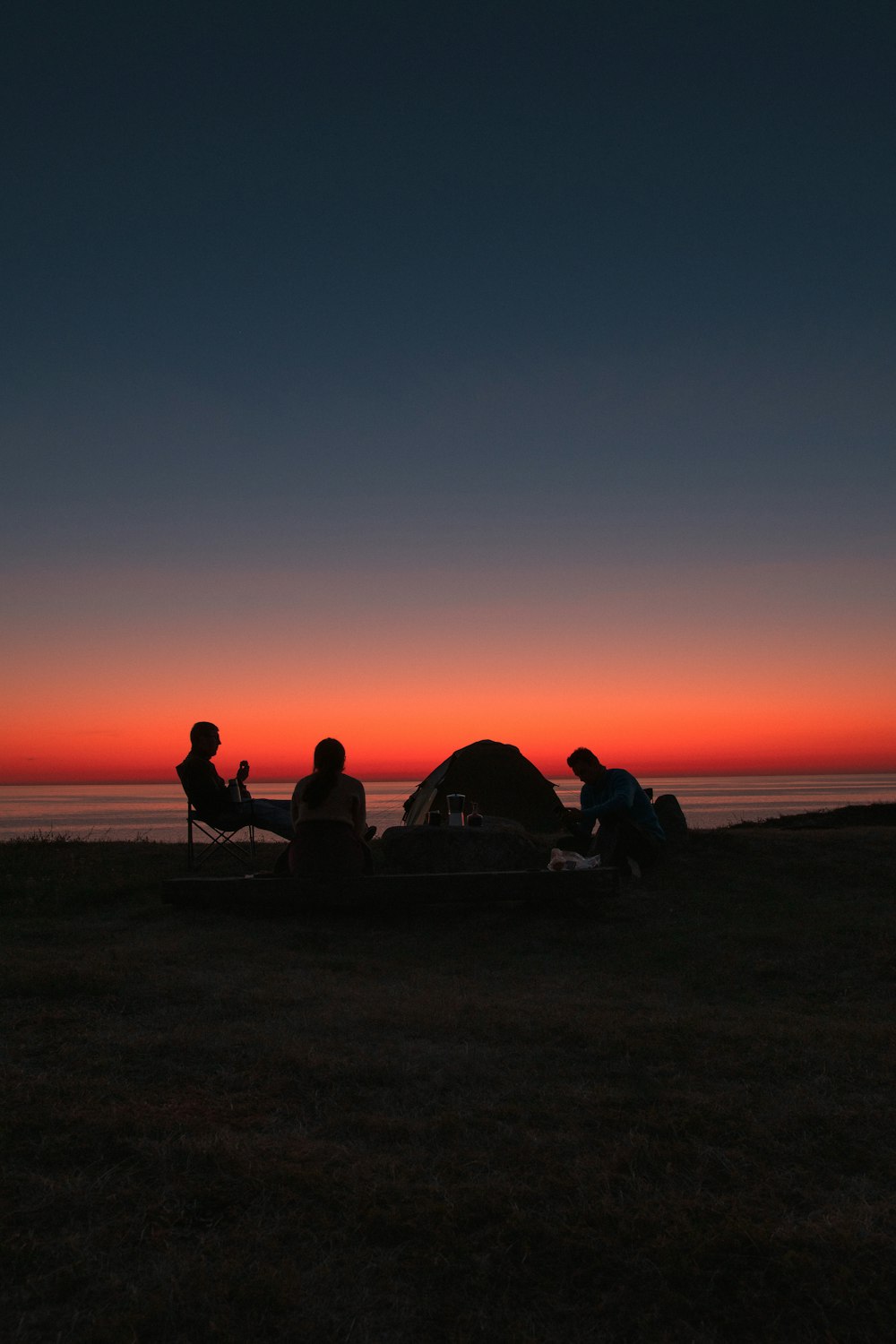 silhouette of 2 person sitting on beach during sunset