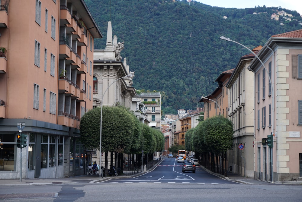 a street lined with tall buildings with a mountain in the background