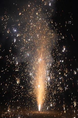 A vibrant fountain firework spraying multicolored sparks on a dark background