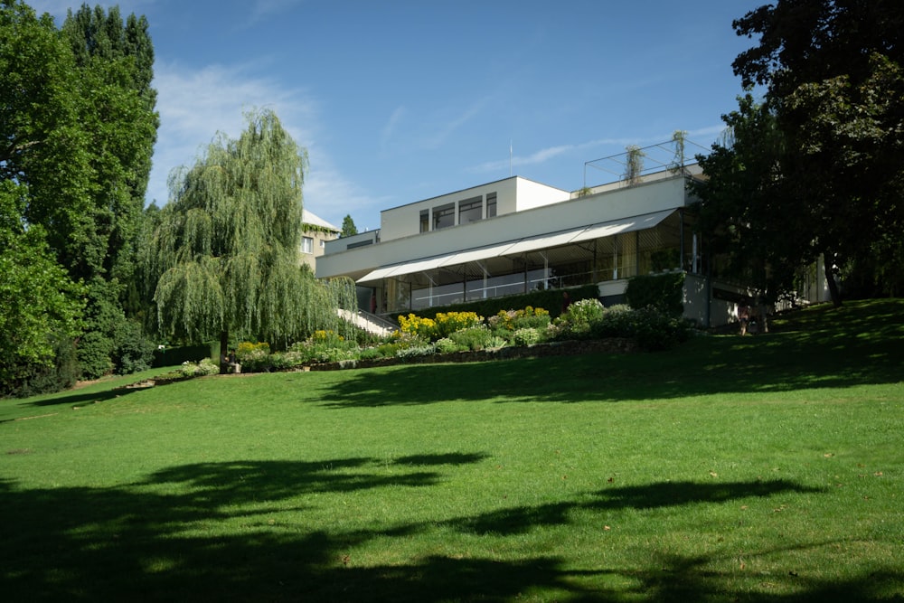 昼間の緑の芝生の近くの白いコンクリートの家