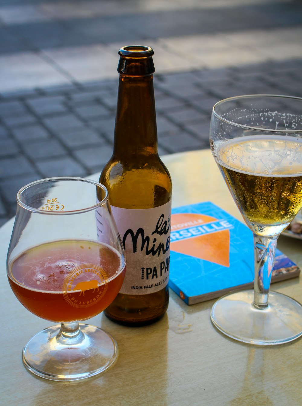 brown glass bottle beside clear drinking glass