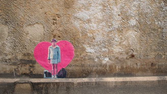 A vibrant street wall featuring a newly discovered Banksy stencil of a girl releasing a heart-shaped balloon.