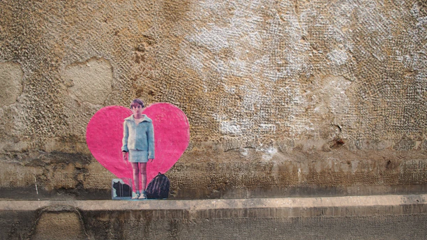 A vibrant street wall featuring a newly discovered Banksy stencil of a girl releasing a heart-shaped balloon.