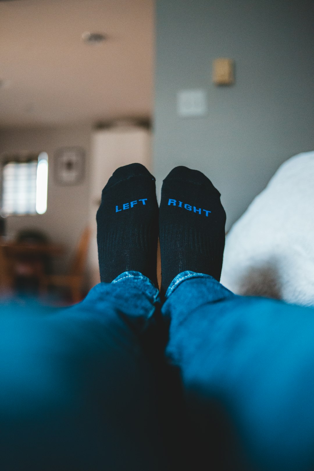 person in blue denim jeans and black socks