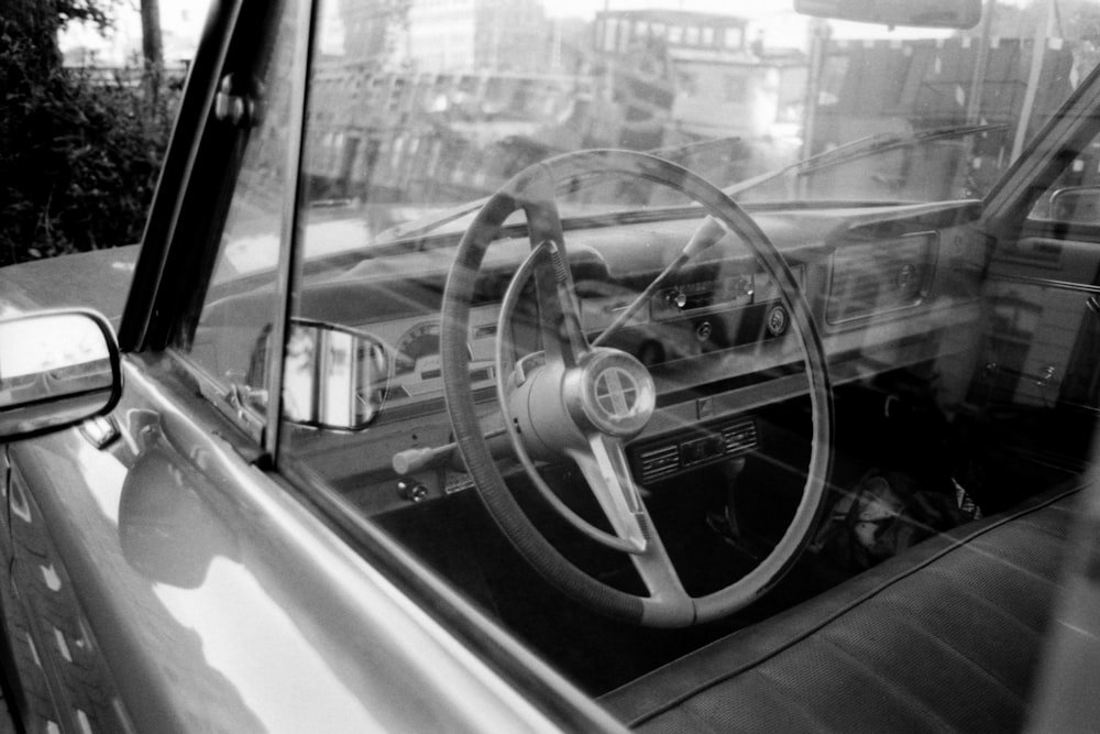 grayscale photo of car steering wheel