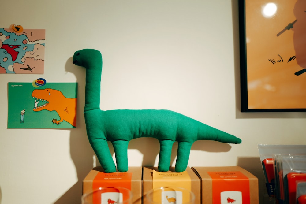 green dinosaur plastic toy on brown cardboard box