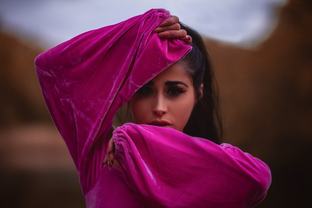 girl in purple hijab covering her face with purple textile