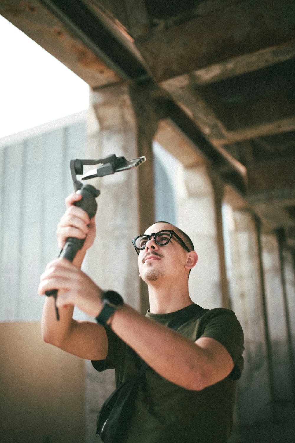 man in black crew neck t-shirt holding gray metal tool