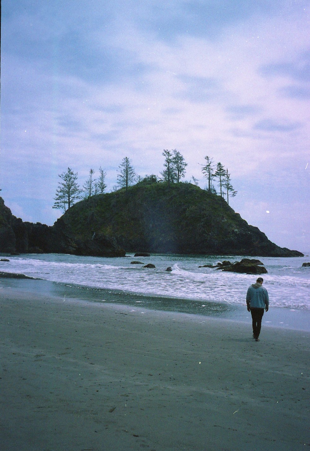 man in green shirt standing on seashore during daytime