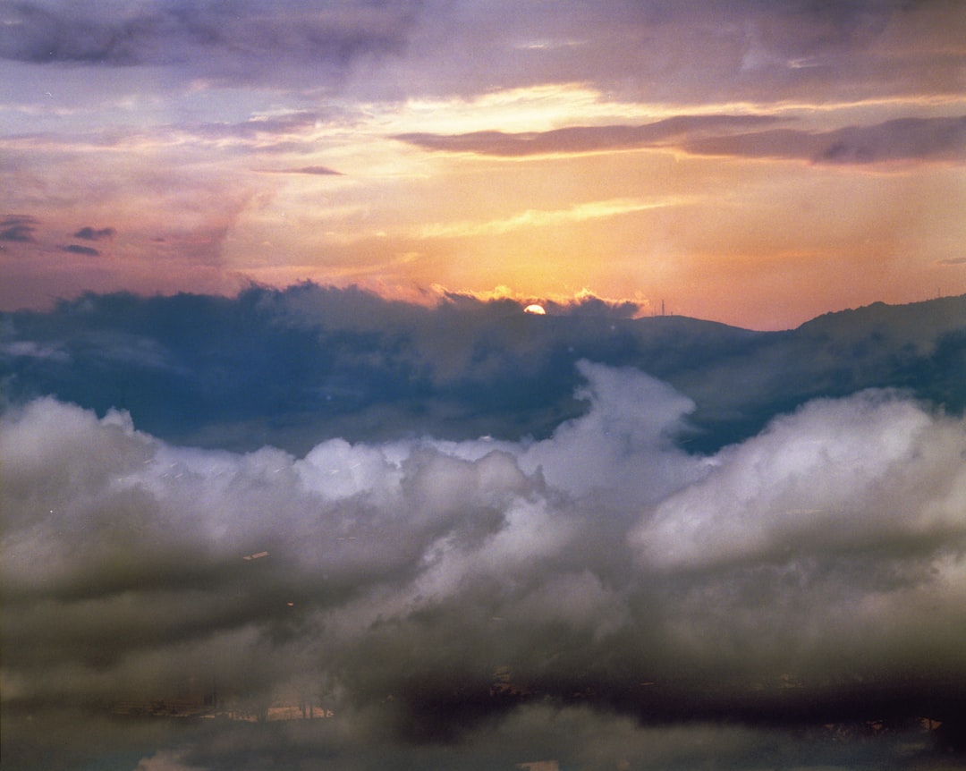 white clouds over mountains during sunset