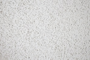 Before and after shot of a popcorn ceiling removal revealing a smooth, modern ceiling.