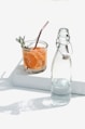 clear glass bottle beside orange juice in clear glass bottle