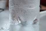Close-up of a clear blue 20L hannah water bottle with droplets on its surface.